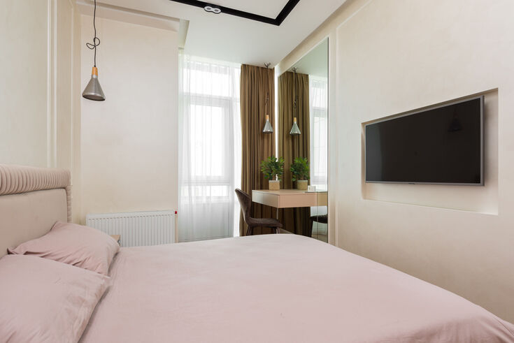 Compact bedroom where the bed fills most of the floor space beside a small desk