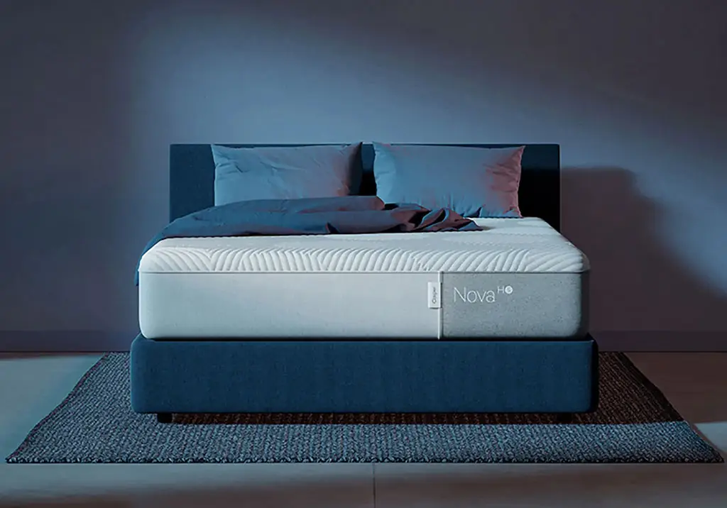 6.	Casper cooling mattress with cool to touch cover placed over a bed with blue shade in the background and bed.